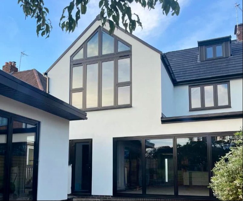 A white rendered gable end with dark window frames